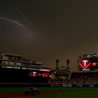 As the sun breaks through, a rainbow and lighting are seen over Great American Ball Park at the end of a weather delay before a baseball game between the Cincinnati Reds and the Minnesota Twins, Wednesday, June 18, 2025, in Cincinnati. (AP Photo/Carolyn Kaster)