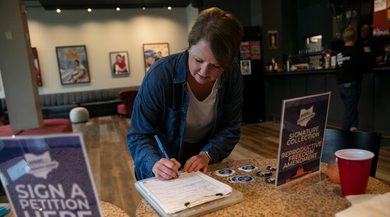 An Ohio voter, Lysha Ingle, signs a petition to place an amendment protecting abortion rights in the state constitution on the ballot, in Cincinnati, April, 21, 2023. After abortion rights supporters swept six ballot measures last year, Republican legislatures seek to make it harder to get on the ballot, and harder to win if there is a vote. (Maddie McGarvey/The New York Times)