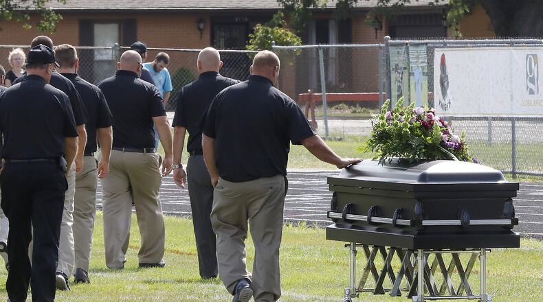 One of the Greenon High School football coaches touches Connor Williams’ casket as the coarches walk off the field after speaking during a joint funeral for student athletes Connor and David Waag at school’s football stadium Friday. Connor and David were killed in a car accident last Sunday. Bill Lackey/Staff