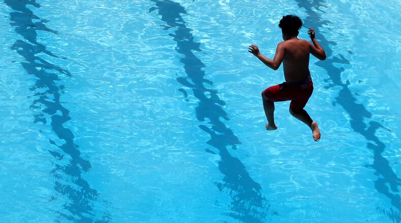 A young swimmer bounces into the water off a diving board at Splash Zone water park in Springfield Tuesday, May 31, 2022. The pool opened for the summer season on Saturday. BILL LACKEY/STAFF