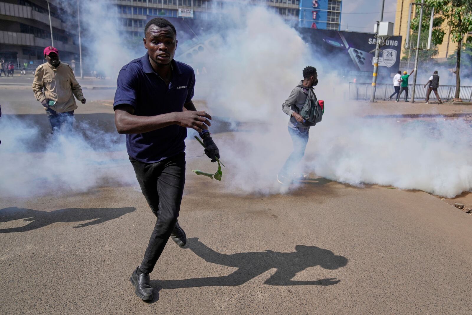 Protesters scatter as police fire teargas at them during a demonstration in downtown Nairobi, Kenya, Wednesday, June 25, 2025. (AP Photo/Brian Inganga)