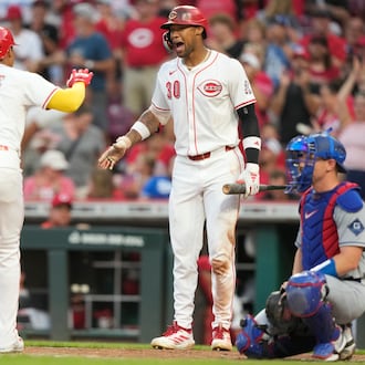 Cincinnati Reds' Noelvi Marte (16) is greeted by Will Benson (30) after Marte hit a solo home run during the fourth inning of a baseball game, Tuesday, July 29, 2025, in Cincinnati. At left is home plate umpire Jansen Visconti (52), and at right is Los Angeles Dodgers catcher Will Smith. (AP Photo/Carolyn Kaster)