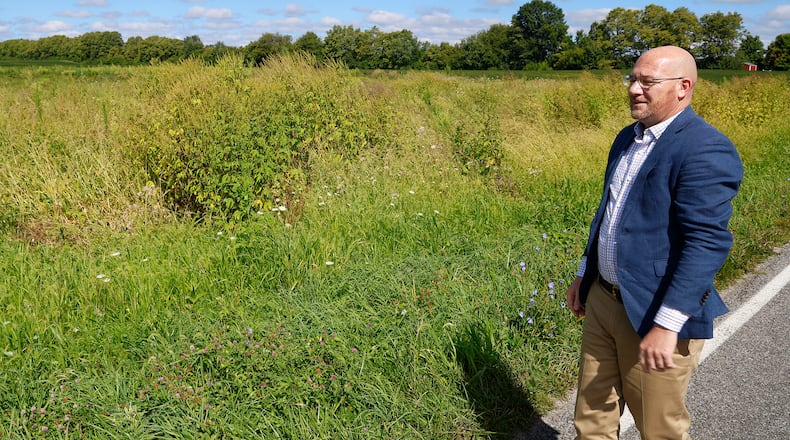 Randy Bridge, New Carlisle City Manager, looks over the vacant field along Addison-New Carlisle Road where a housing development has been proposed Thursday, August 31, 2023. BILL LACKEY/STAFF