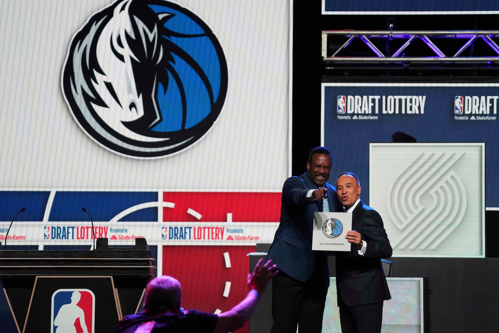 Dallas Mavericks' Rolando Blackman, left, and NBA Deputy Commissioner Mark Tatum, right, pose for photos after Tatum announced that the Mavericks had won the first pick in the NBA draft during the draft lottery in Chicago, Monday, May 12, 2025. (AP Photo/Nam Y. Huh)