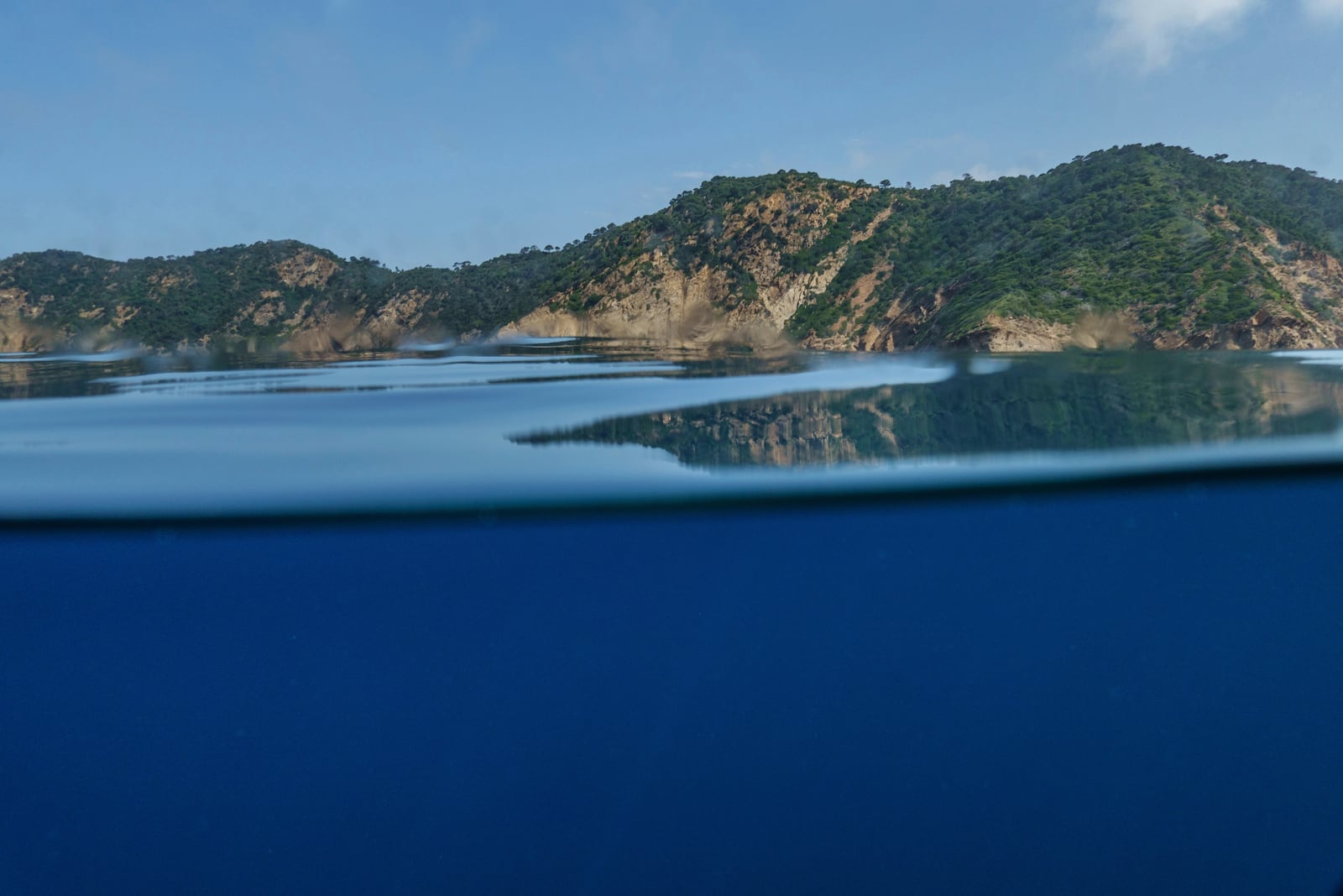 Mountains are reflected in the waters of France's Port-Cros National Park ahead of the U.N. Ocean Conference, Saturday, June 7, 2025, (AP Photo/Annika Hammerschlag)