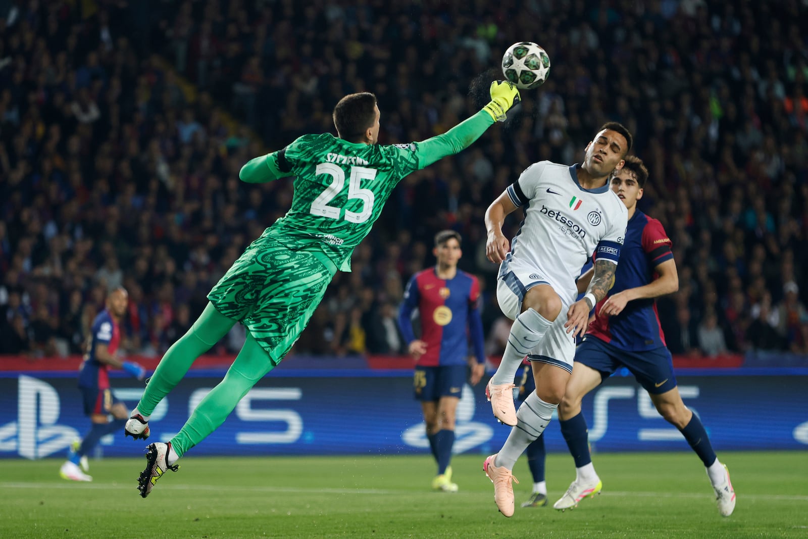 Barcelona's goalkeeper Wojciech Szczesny clears the ball in front of Inter Milan's Lautaro Martinez during the Champions League semifinal first leg soccer match between Barcelona and Inter Milan at the Lluis Companys Olympic Stadium in Barcelona, Spain, Wednesday, April 30, 2025. (AP Photo/Joan Monfort)