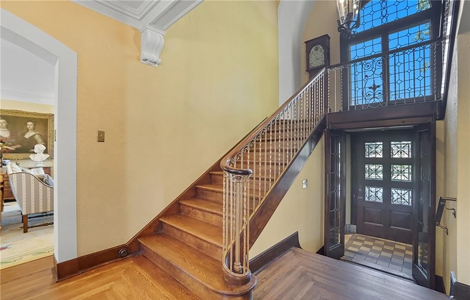 The grand staircase off the foyer has wood steps and a landing with a decorative window and chandelier. There is also an elevator in the home accesses all floors. CONTRIBUTED