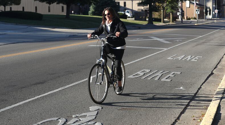 Cathy Blakeley rides her bicycle in the bike lane that runs along South Center Street in Springfield Tuesday, Oct. 4, 2022. BILL LACKEY/STAFF
