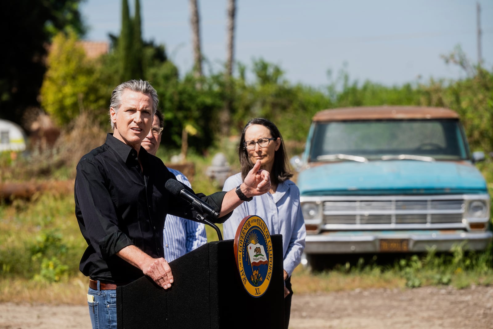 California Gov. Gavin Newsom discusses President Donald Trump's tariffs, as almond farmer Christine Gemperle, listens, during a press conference on Wednesday, April 16, 2025, at an almond farm in Ceres, Calif. (AP Photo/Noah Berger)