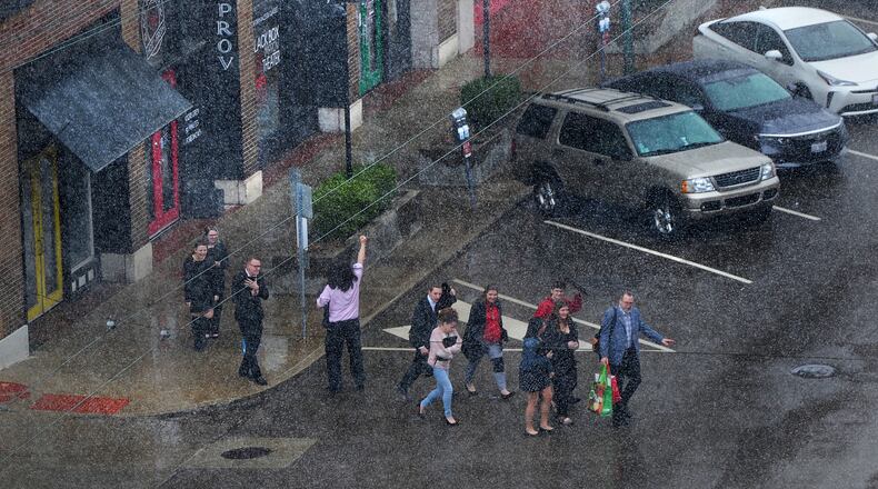 People hustle across Third Street as the month of March comes in like a lion on Friday March 11, 2022. MARSHALL GORBY\STAFF