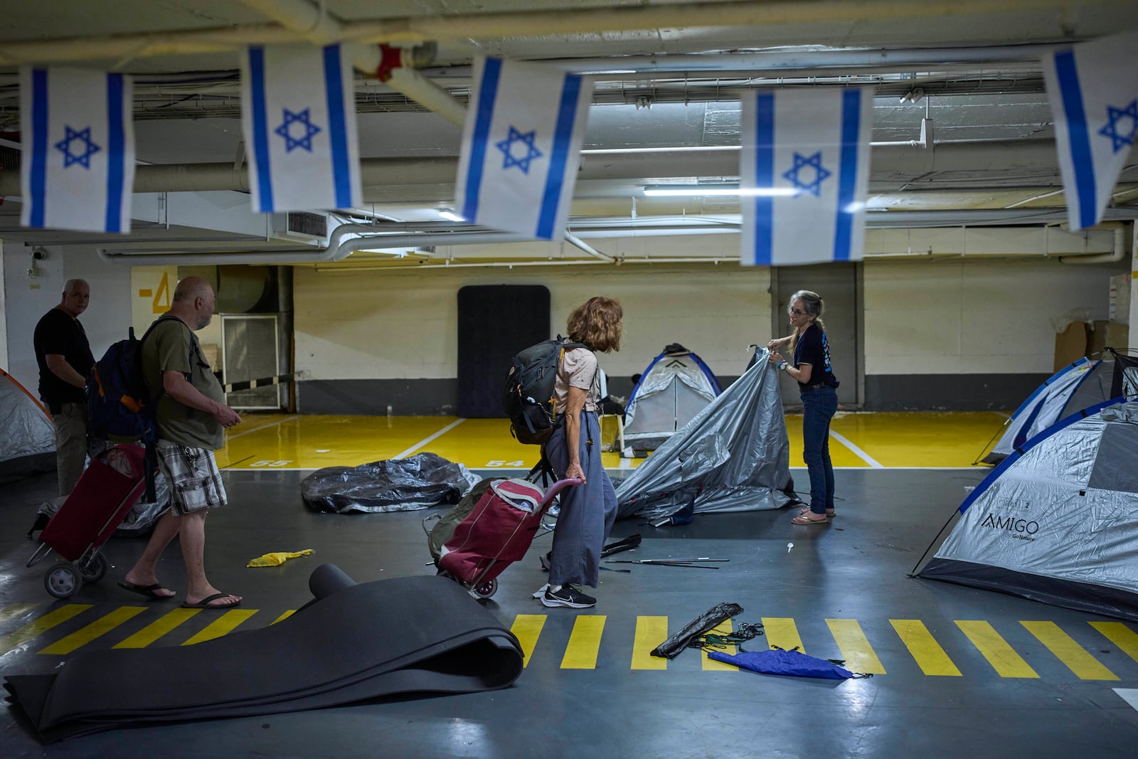 People fold tents at an underground shelter they stayed in during the war with Iran after the ceasefire was announced in Tel Aviv, Israel, Tuesday, June 24, 2025. (AP Photo/Ohad Zwigenberg)