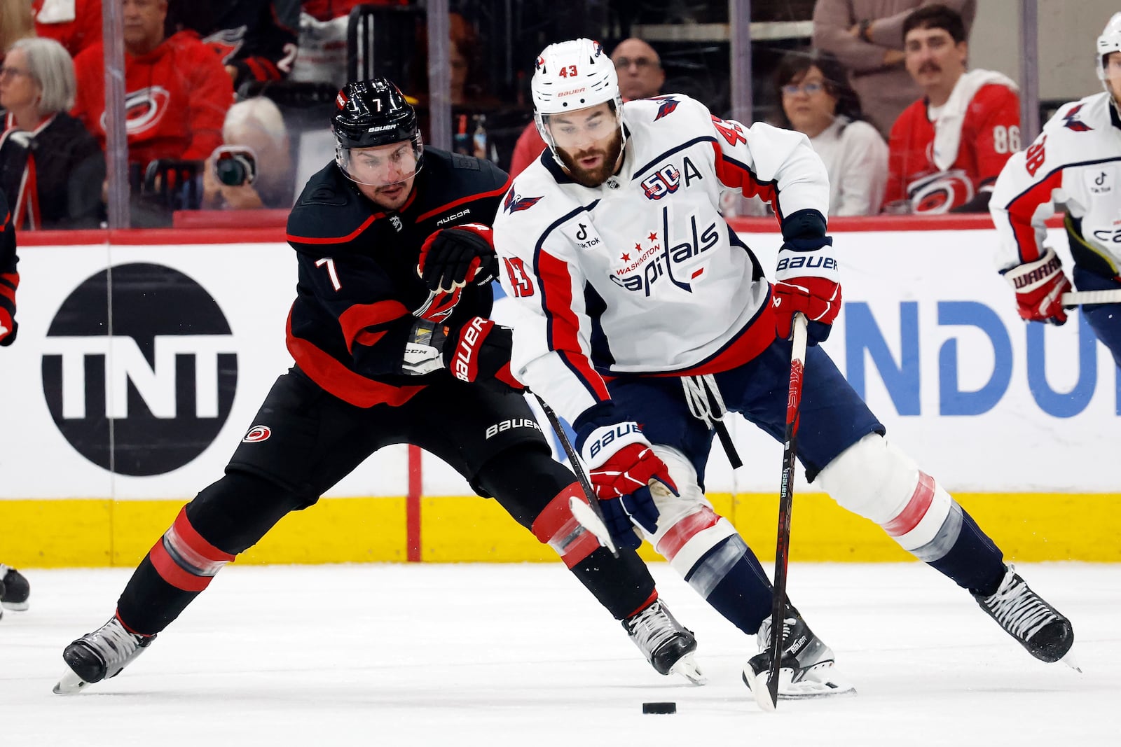 Washington Capitals' Tom Wilson (43) controls the puck in front of Carolina Hurricanes' Dmitry Orlov (7) during the second Game 4 of a second-round NHL hockey playoff series in Raleigh, N.C., Monday, May 12, 2025. (AP Photo/Karl DeBlaker)