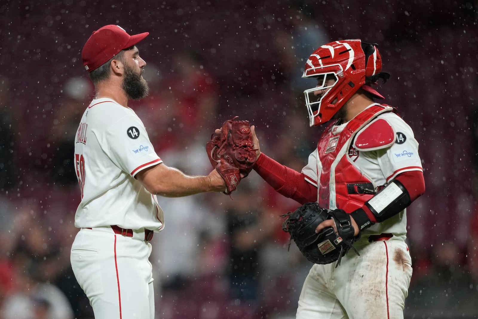 Cincinnati Reds pitcher Sam Moll, left, and Cincinnati Reds catcher Jose Trevino celebrate after winning a baseball game against the Philadelphia Phillies Tuesday, Aug. 12, 2025, in Cincinnati. (AP Photo/Carolyn Kaster)