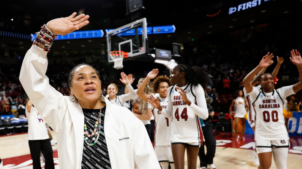 South Carolina head coach Dawn Staley, left, leads her team in waving to supporters after defeating Southern California in the second round of the NCAA college basketball tournament, Monday, March 23, 2026, in Columbia, S.C. (AP Photo/Nell Redmond)