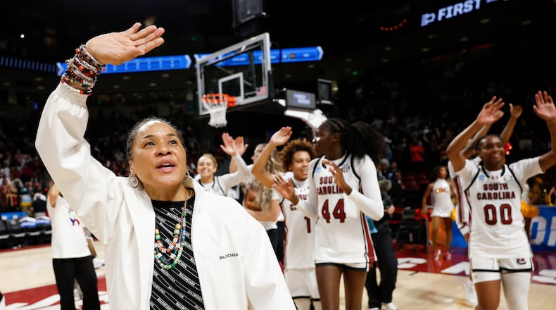 South Carolina head coach Dawn Staley, left, leads her team in waving to supporters after defeating Southern California in the second round of the NCAA college basketball tournament, Monday, March 23, 2026, in Columbia, S.C. (AP Photo/Nell Redmond)