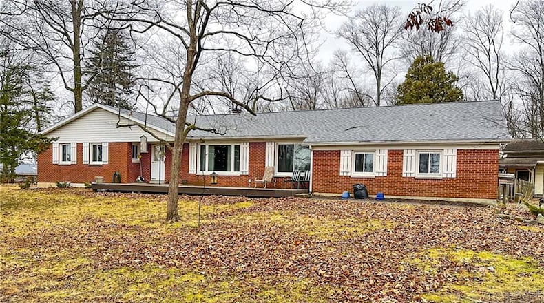 The front of the brick ranch features a new wooden deck and a gravel driveway leading to the two-car attached and two-car detached garages. Contributed photos