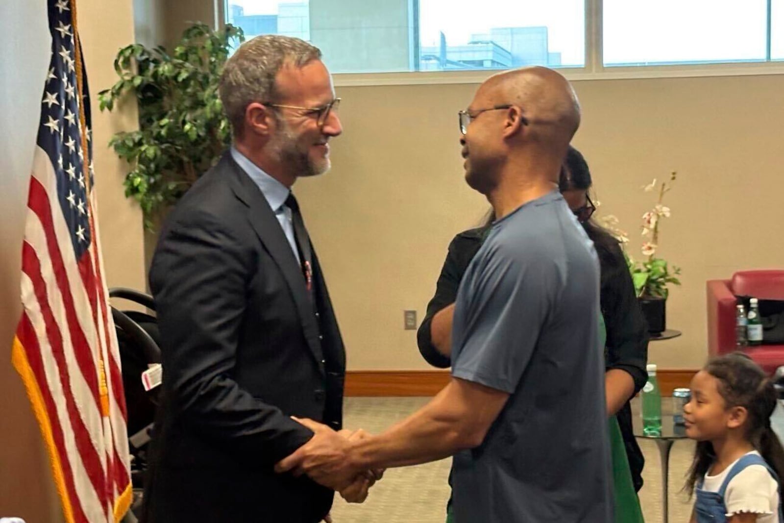In this image released by the U.S. State Dept., Adam Boehler, the Trump administration's top envoy for hostage affairs, left, greets military contractor Tony Holden, who was recently released from Kuwait, at Washington Dulles International Airport, in Chantilly, Va., on Wednesday, April 30, 2025. (U.S. State Dept. via AP)