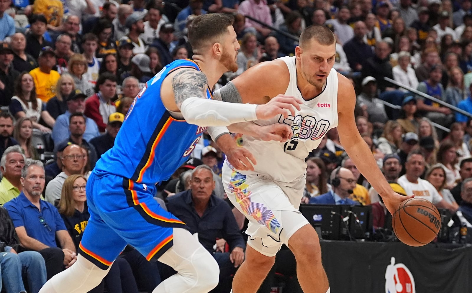 Denver Nuggets center Nikola Jokic, right, drives past Oklahoma City Thunder center Isaiah Hartenstein in the first half of Game 6 in the Western Conference semifinals of the NBA basketball playoffs Thursday, May 15, 2025, in Denver. (AP Photo/David Zalubowski)