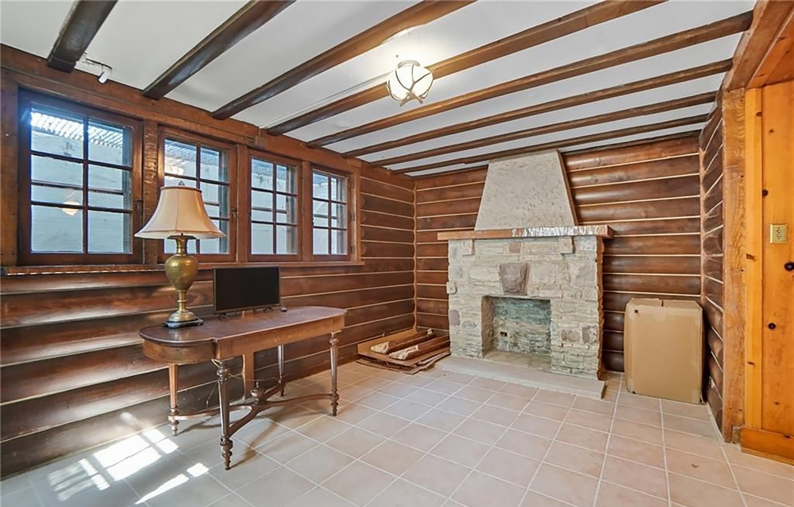 The basement features a unique "log cabin" room with stone fireplace, tile flooring and beamed ceiling. CONTRIBUTED