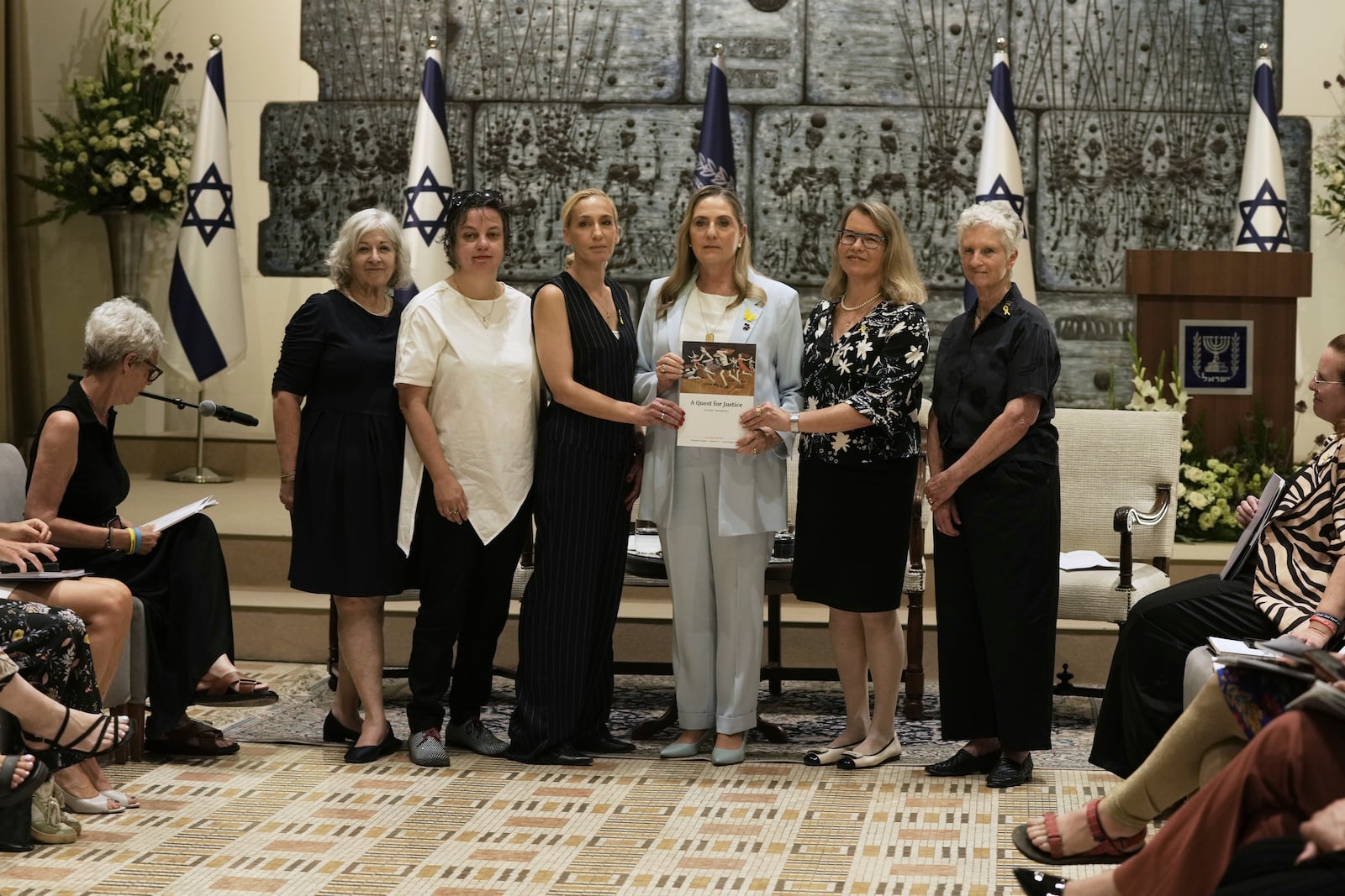 Israel's first lady Michal Herzog, center, is presented with a report by the Dinah Project on sexual violence committed on Oct. 7, 2023 by Hamas, in Jerusalem, Tuesday, July 8, 2025. (AP Photo/Maya Alleruzzo)