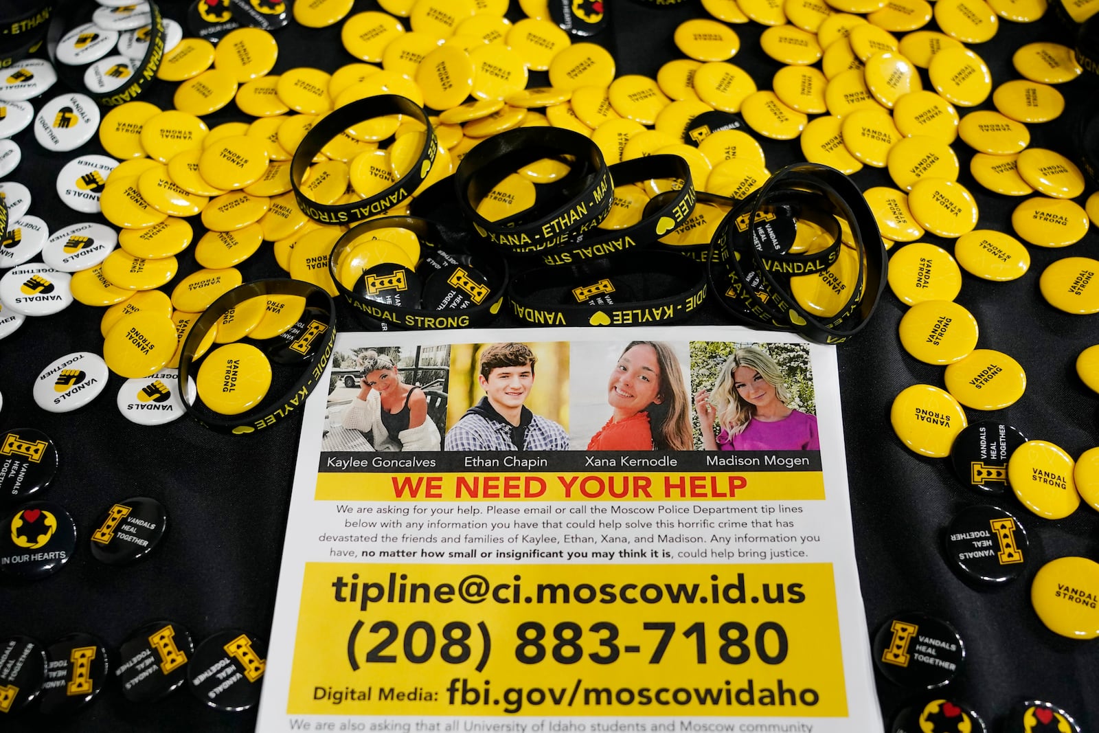 FILE - A flyer seeking information about the killings of four University of Idaho students who were found dead is displayed on a table along with buttons and bracelets on Nov. 30, 2022, during a vigil in memory of the victims in Moscow, Idaho. (AP Photo/Ted S. Warren, File)