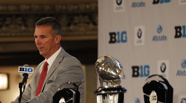 Ohio State coach Urban Meyer addresses the media with the Big Ten championship trophies next to him at Big Ten Football Media Days at the Hilton in Chicago on Monday, July 28, 2014. David Jablonski/Staff
