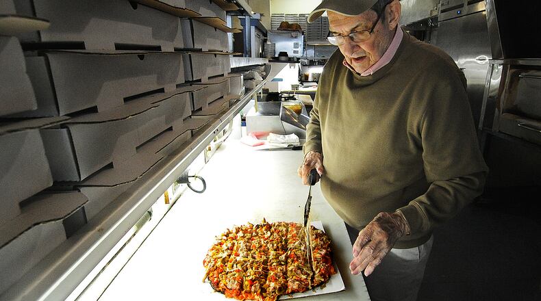 Ron Holp cuts a pizza fresh from the oven at Ron's Pizza in downtown Miamisburg Thursday, Jan. 5, 2023. Holp died Sunday, Nov. 3. MARSHALL GORBY/STAFF