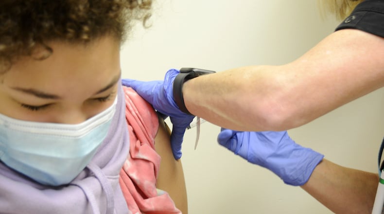 Brooklyn Brundidge, 12, a seventh-grader at Garfield Middle School in Hamilton, receives a vaccine shot on Wednesday, Sept. 14, 2022, from Public Health Nurse Betsy Waldeck at the Butler County General Health District clinic in downtown Hamilton. MICHAEL D. PITMAN/STAFF
