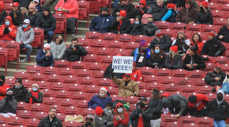 A fan holds up a sign as the Reds play the Cardinals on Opening Day on Thursday, April 1, 2021, at Great American Ball Park in Cincinnati. David Jablonski/Staff