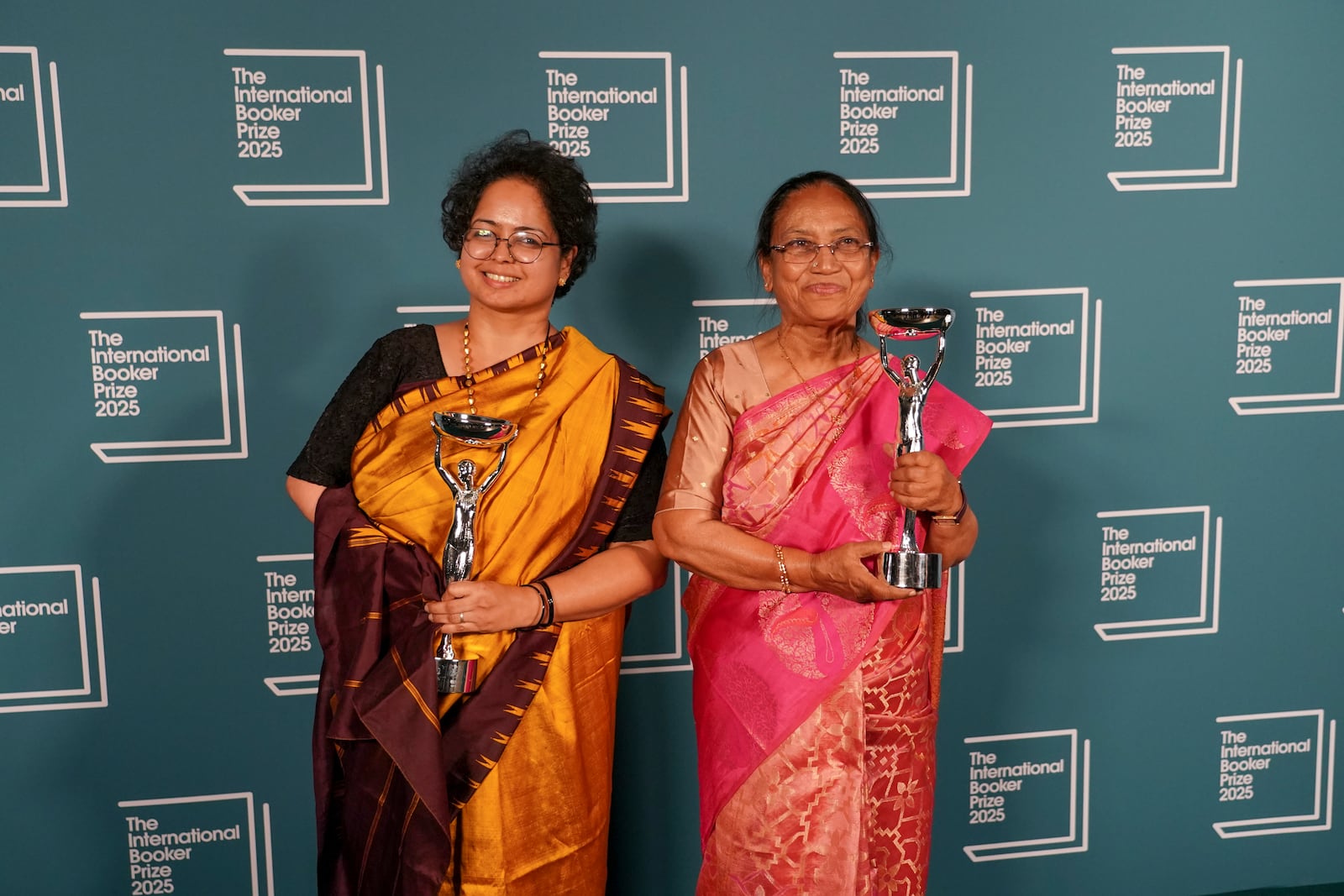 Banu Mushtaq, author of 'Heart Lamp', right, and Deepa Bhasthi hold the trophies after winning the International Booker Prize, in London, Tuesday, May 20, 2025.(AP Photo/Alberto Pezzali)