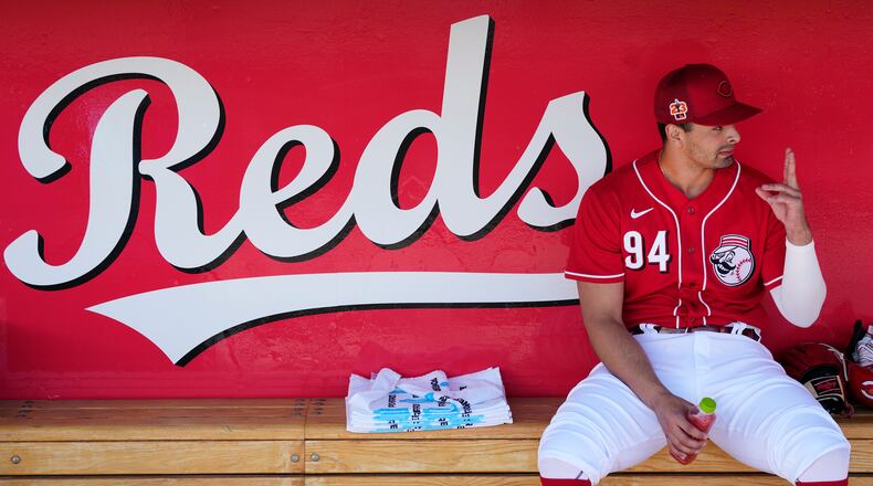 Cincinnati Reds' Christian Encarnacion-Strand talks to a teammate in the dugout prior to a spring training baseball game against the Cleveland Guardians, Saturday, Feb. 25, 2023. (AP Photo/Ross D. Franklin)