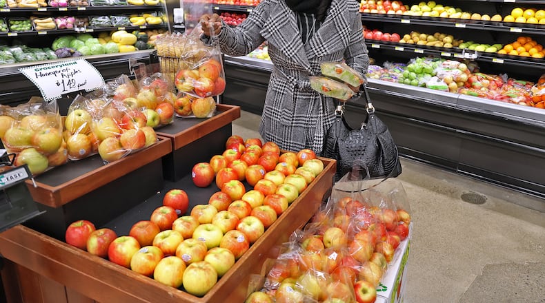Nettie Carter-Smith picks up some fresh fruits and vegetables in December at the new Groceryland store on South Limestone Street. The grocery store will be donating this year's profits to community efforts. BILL LACKEY/STAFF
