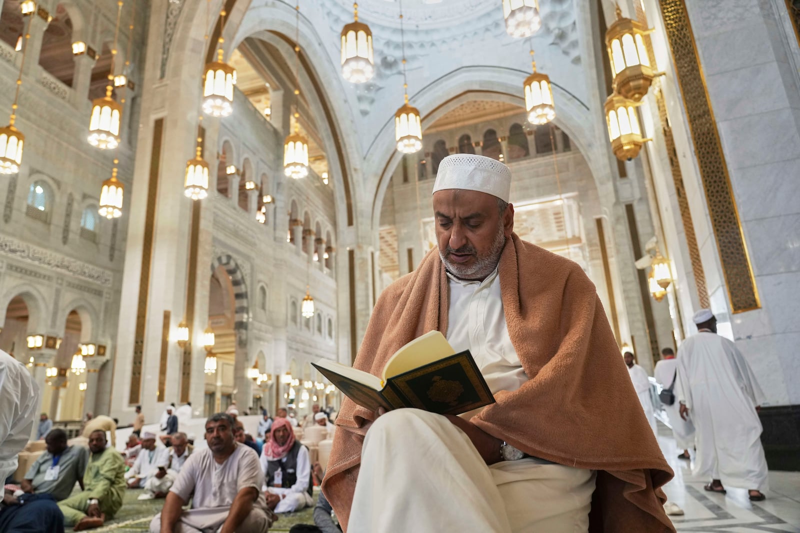 A Muslim pilgrim reads a copy of Islam's holy book Quran at the Grand Mosque during the annual Hajj pilgrimage in Mecca, Saudi Arabia, Tuesday, June 3, 2025. (AP Photo/Amr Nabil)