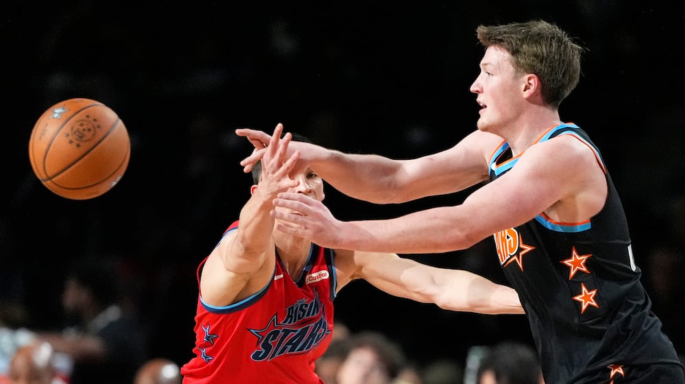 Team T-Mac guard Kon Knueppel (7) of the Charlotte Hornets, right, passes while under pressure from Team Vince guard Egor Demin (8) of the Brooklyn Nets during an NBA basketball's Rising Stars event Friday, Feb. 13, 2026, in Inglewood, Calif. (AP Photo/Mark J. Terrill)
