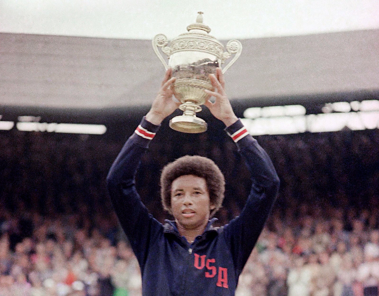 FILE - In this July 5, 1975, file photo, Arthur Ashe holds the men's singles trophy after defeating fellow American Jimmy Conners in the final of the men's singles championship at the All England Lawn Tennis Championship in Wimbledon, London. (AP Photo/File)