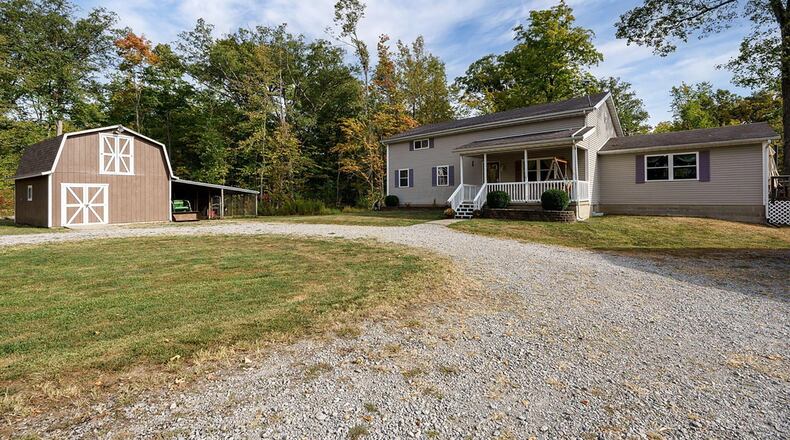 The front of the home at 3001 Wideman Road in Urbana has a covered porch and a gravel driveway connects all the buildings. CONTRIBUTED