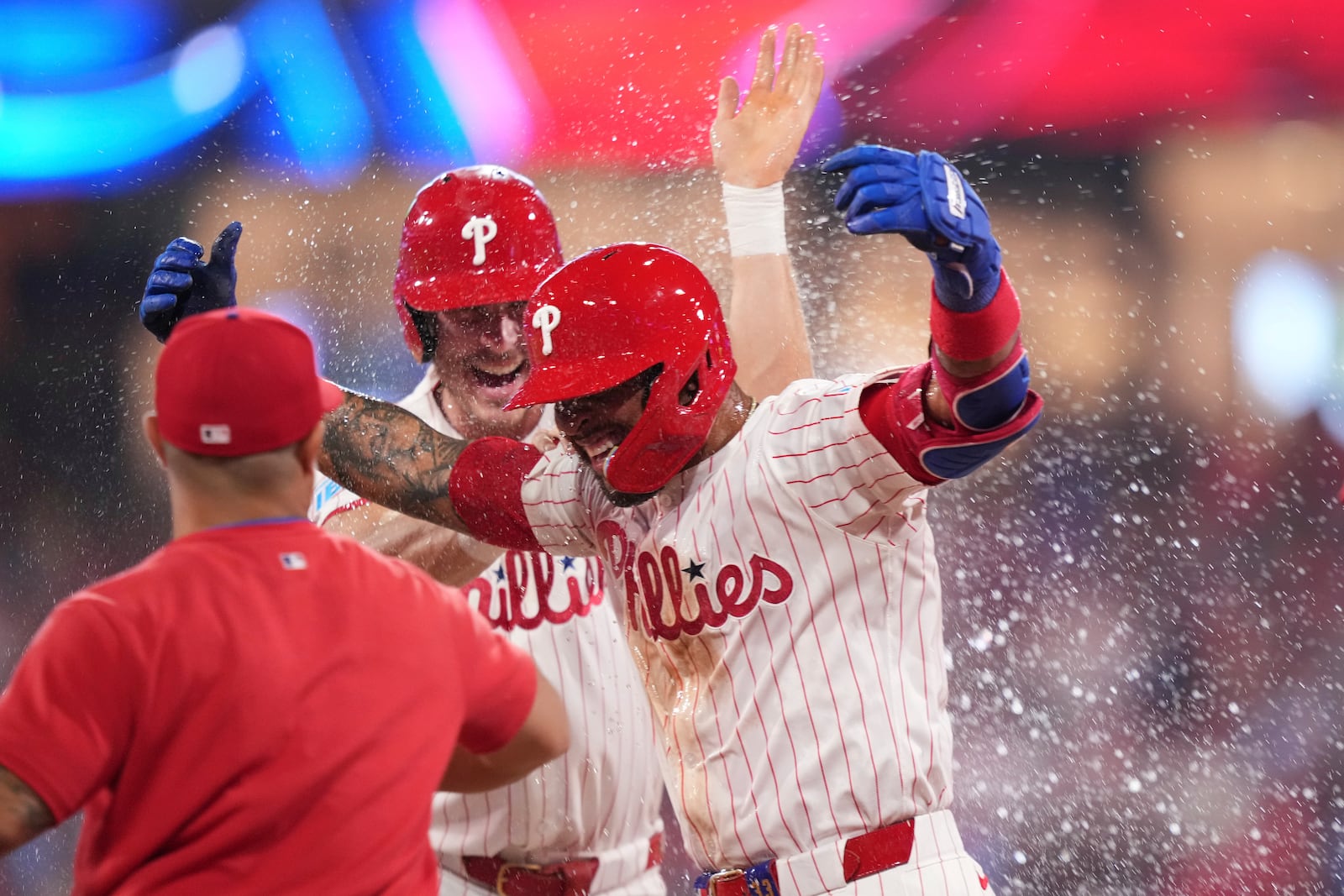 Philadelphia Phillies' Edmundo Sosa, right, celebrates with teammates after the Phillies won a baseball game against the Boston Red Sox on catcher's interference with the bases loaded in the 10th inning Monday, July 21, 2025, in Philadelphia. (AP Photo/Matt Slocum)
