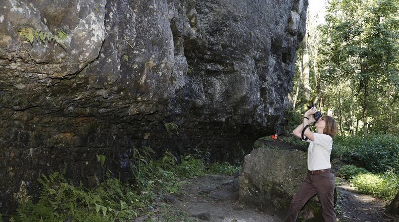 Carol Kennard, executive director of the Clark County Park District, takes photos of the Mad River Gorge climbing area Friday. The Clark County Park District has recently purchased Mad River Gorge and pulled over 125,000 pounds of trash from the gorge, but they still have more to go. Leave No Trace Behind has chosen the gorge as one of 15 hot spots in the country to assist with this process. Bill Lackey/Staff