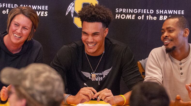 Shawnee’s Robie Glass (center) with his parents Rob Glass and Nikki Johnson during Wednesday signing day ceremony. Glass will play college football at Kent State. Jeff Gilbert/CONTRIBUTED