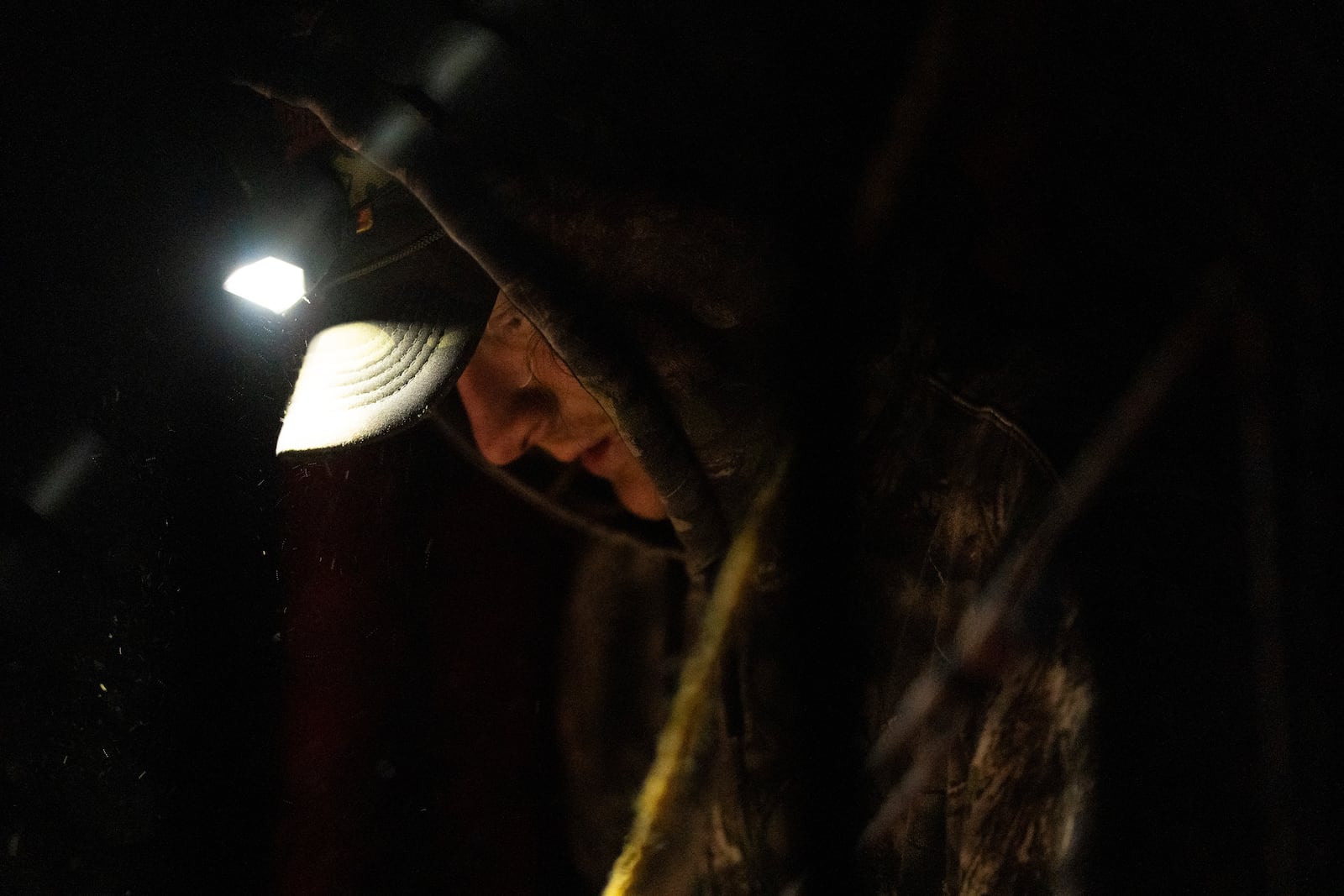 Mike Shelton works to attach a hitch to a vehicle as he loads up his belongings at a homeless encampment in Deschutes National Forest Wednesday, April 30, 2025 near Bend, Ore. (AP Photo/Jenny Kane)
