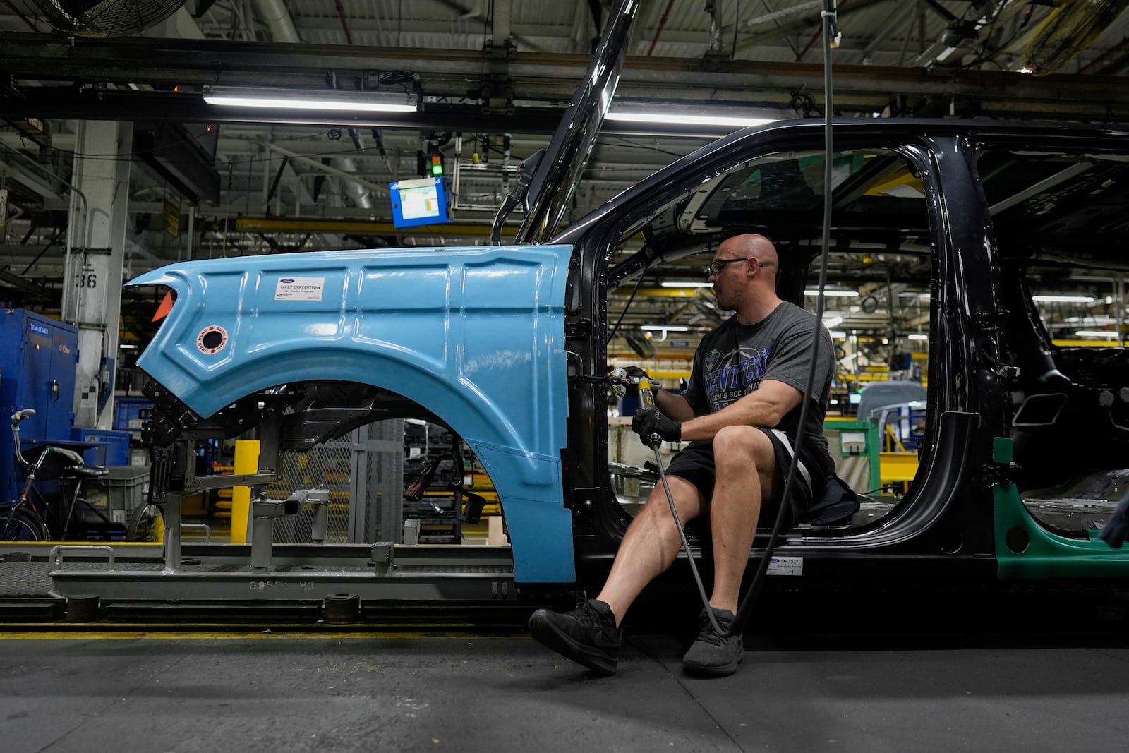 A vehicle assembly technician works on a 2025 Ford Expedition during a media tour to launch the 2025 Ford Expedition at the Ford Motor Company Kentucky Truck Plant, Wednesday, April 30, 2025, in Louisville, Ky. (AP Photo/Carolyn Kaster)
