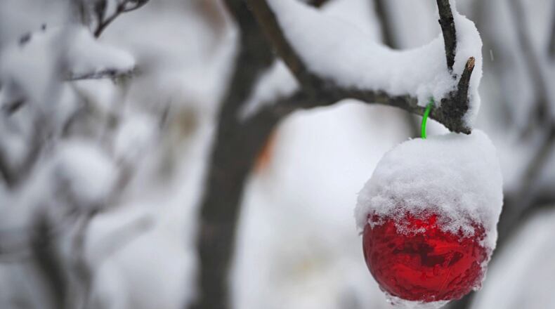 Snow covered much of the area, including this tree and Christmas ornament near Fairborn, after the Miami Valley's first snowfall of 2020 on Nov. 30. MARSHALL GORBY/STAFF