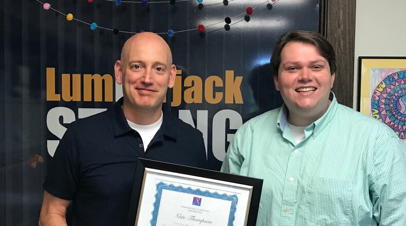 Nate Thompson, left, music teacher at Edwin D. Smith Elementary in Oakwood, is the recipient of the 2021 Springfield Symphony Orchestra Music Educator of the Year. Thompson kept his students learning and singing virtually and in person amid pandemic conditions over the past year. Here he accepts the award from Axl Pons, Symphony Education and Operations Manager. Contributed photo.