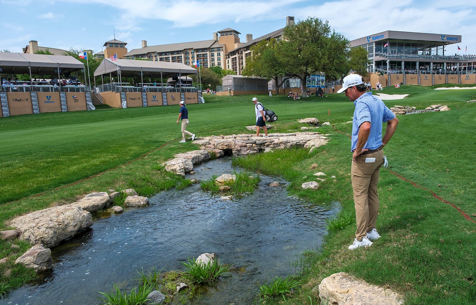 Kevin Kisner looks for his ball in a water hazard on the 18th hole during the first round of the Texas Open golf tournament, Thursday, April 3, 2025, in San Antonio, Texas. (AP Photos/Rodolfo Gonzalez)