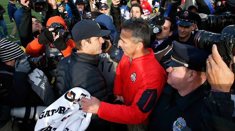 ANN ARBOR, MI - NOVEMBER 28: Head coach Urban Meyer of the Ohio State Buckeyes shakes hands with head coach Jim Harbaugh of the Michigan Wolverines after a 42-13 Ohio State win at Michigan Stadium on November 28, 2015 in Ann Arbor, Michigan. (Photo by Gregory Shamus/Getty Images)