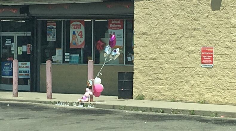 A makeshift memorial was in place where Donna Ruth Brown was fatally shot outside the Family Dollar on James H. McGee Boulevard in Dayton. MIKE CAMPBELL/STAFF