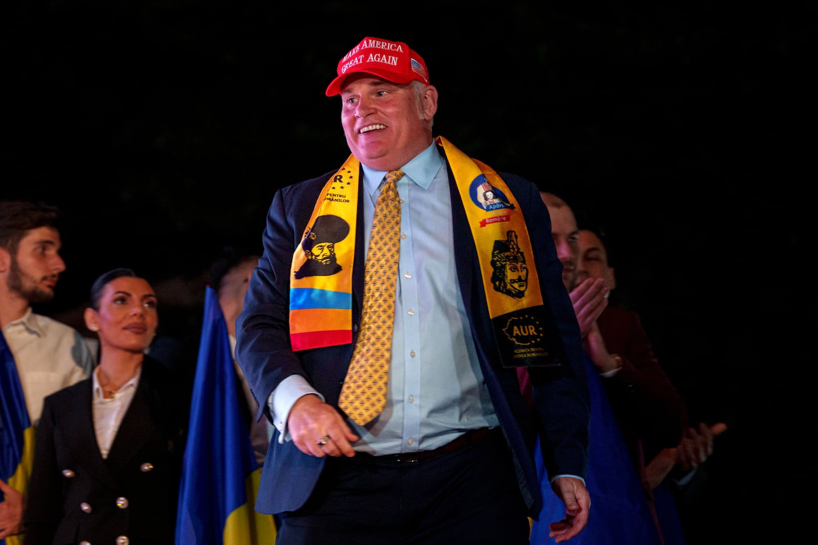 U.S. activist Brian Brown walks on stage as supporters of Presidential candidate George Simion celebrate the exit poll results outside the headquarters of the Alliance for the Unity of Romanians (AUR) after polls closed for the first round of the country's presidential election redo in Bucharest, Romania, Sunday, May 4, 2025. (AP Photo/Andreea Alexandru)