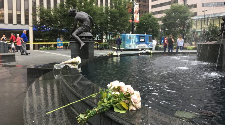 Ten bouquets of flowers decorated the rim of the fountain on Cincinnati's Fountain Square on Friday, Sept. 7, 2018, the day after a shooting in a nearby building. Three people were killed Thursday morning by Omar Santa-Perez, who then was killed by police responding to the active shooter calls. Two other people were seriously injured in the shooting. ERIC SCHWARTZBERG / STAFF