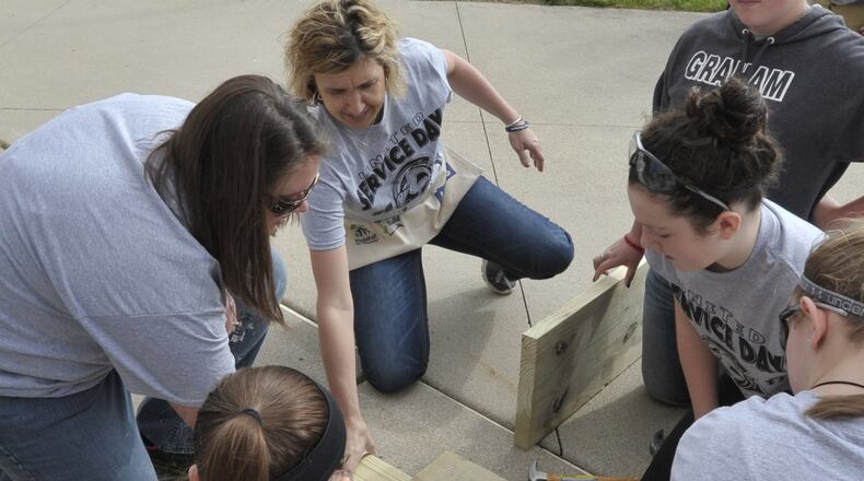 Graham’s teacher of the year, Katie Setty, center, helps a group of student with a Service Day project. Bill Lackey/Staff