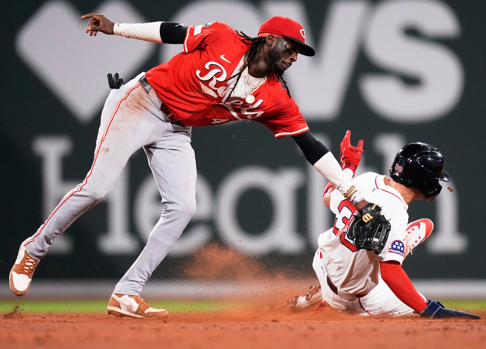 Cincinnati Reds shortstop Elly De La Cruz, left, tags out Boston Red Sox's Marcelo Mayer, right on a steal-attempt during the seventh inning of a baseball game at Fenway Park, Monday, June 30, 2025, in Boston. (AP Photo/Charles Krupa)